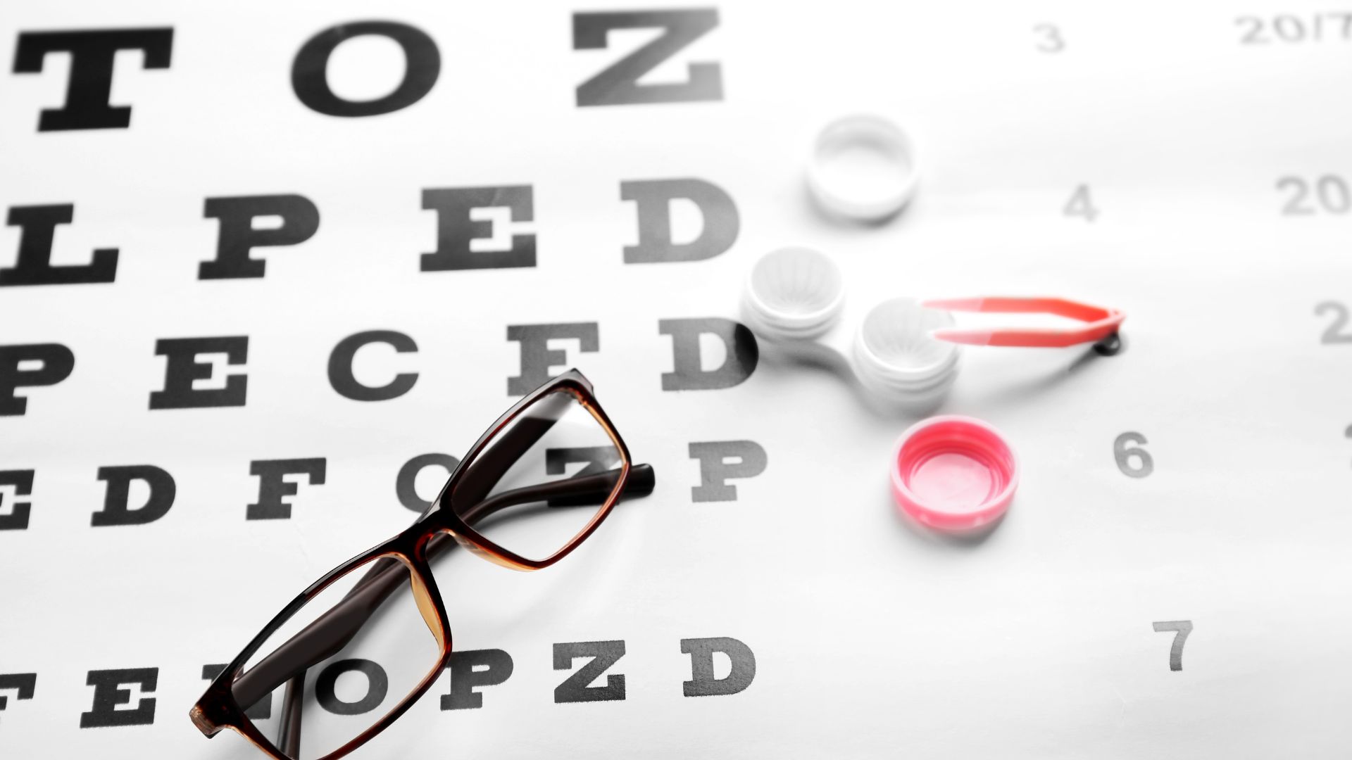 A dimly lit office interior, with a large window overlooking the cityscape of downtown Toronto. On the desk, an array of eye care equipment - ophthalmoscopes, trial lens frames, and spectacle frames in various styles. In the foreground, a pair of eyeglasses and a contact lens case sit side by side, symbolizing the choice between the two vision correction options. The scene is bathed in a warm, professional lighting, conveying a sense of expertise and regulation surrounding vision care in the province of Ontario. Eyeglasses vs. Contact Lenses 005
