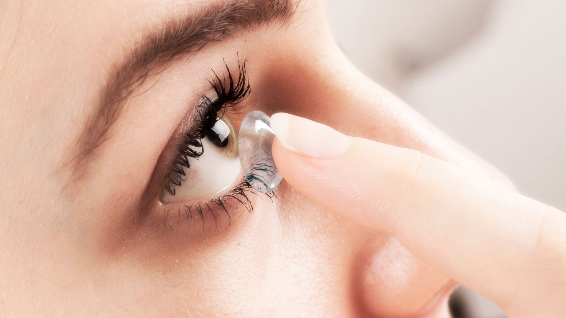 A well-lit, close-up shot of a pair of contact lenses resting on a clean, reflective surface. The lenses are positioned to showcase their transparency and intricate structure, with subtle distortions and refractions visible. In the background, a soft, blurred scene of an eye illustrates the lens' interaction with the human body. The overall atmosphere conveys a sense of precision, safety, and the benefits of contact lens wear, such as improved vision and natural appearance. Eyeglasses vs. Contact Lenses 03
