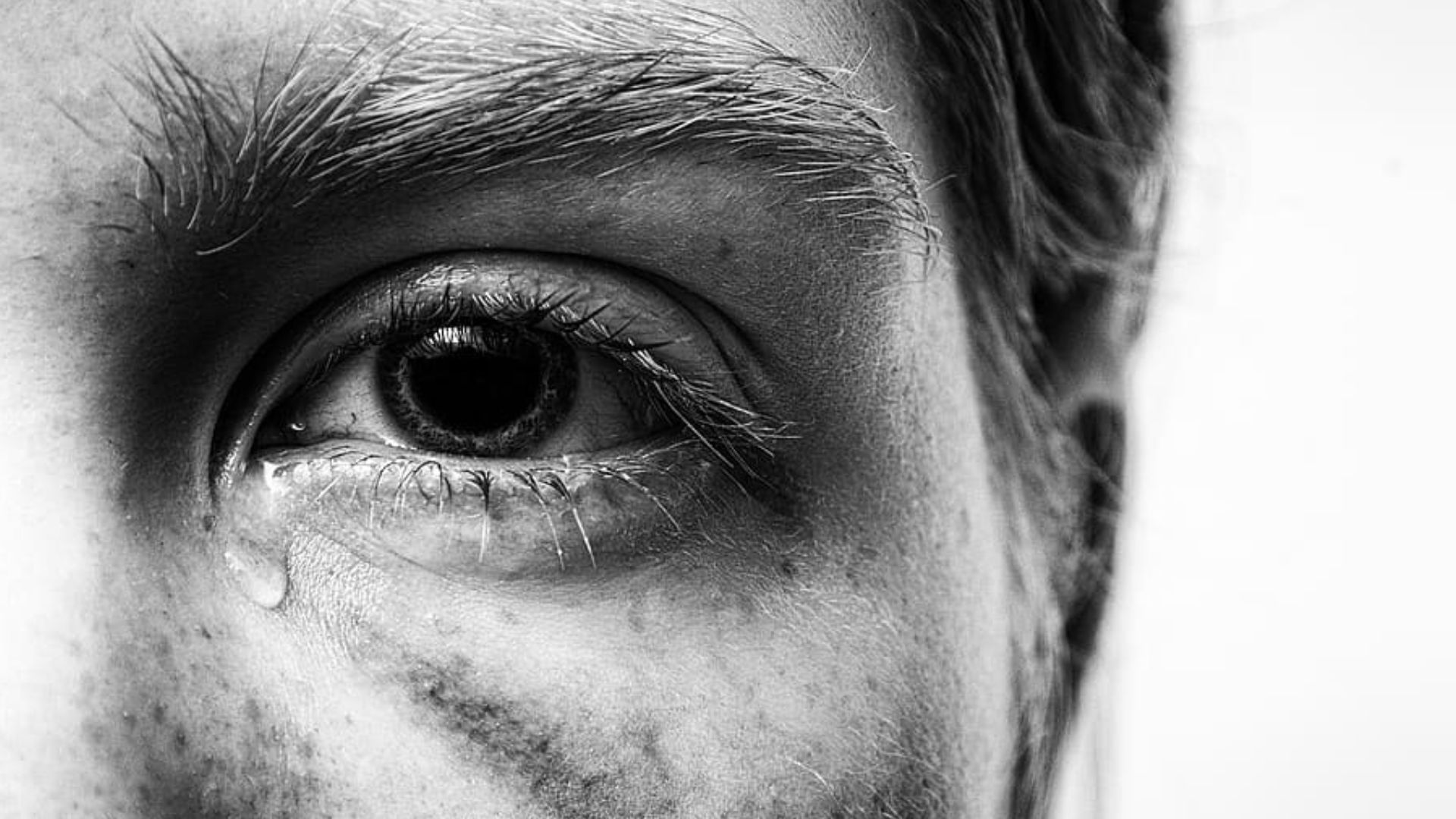A detailed close-up view of a human eye with prominent floating objects, or "eye floaters", drifting across the visual field. The floaters appear as distinct, semi-transparent, string-like shapes with irregular edges, contrasting against a slightly blurry but otherwise clear eye background. The iris is in sharp focus, revealing its intricate texture and coloration. Soft, warm lighting illuminates the eye from the upper right, creating subtle shadows and highlights that accentuate the three-dimensional structure. The overall mood conveys a sense of concern and the need for medical attention regarding the sudden appearance or worsening of these eye floaters. eye floaters 03